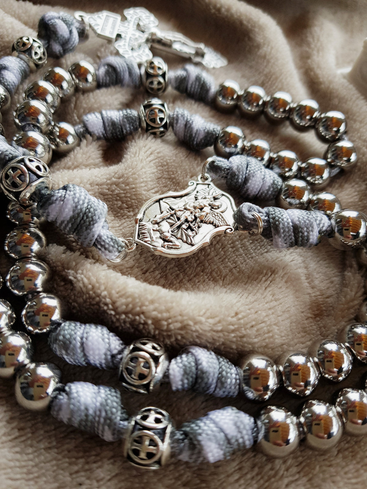 Mittelstück mit dem heiligen Erzengel Michael an einem grau-weißen Paracord-Rosenkranz mit Edelstahlperlen
