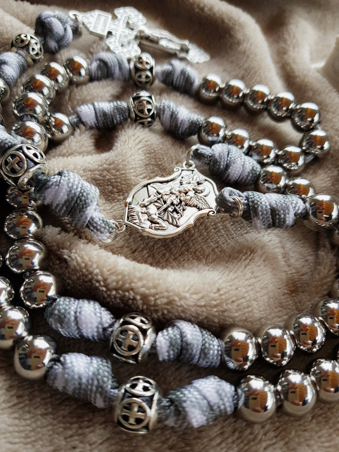Mittelstück mit dem heiligen Erzengel Michael an einem grau-weißen Paracord-Rosenkranz mit Edelstahlperlen